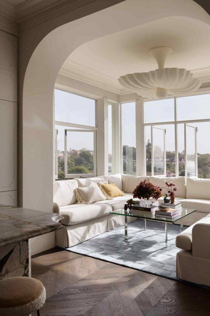 ნათელი თეთრი მისაღები ოთახი დიდი თაღოვანი ფანჯრებით