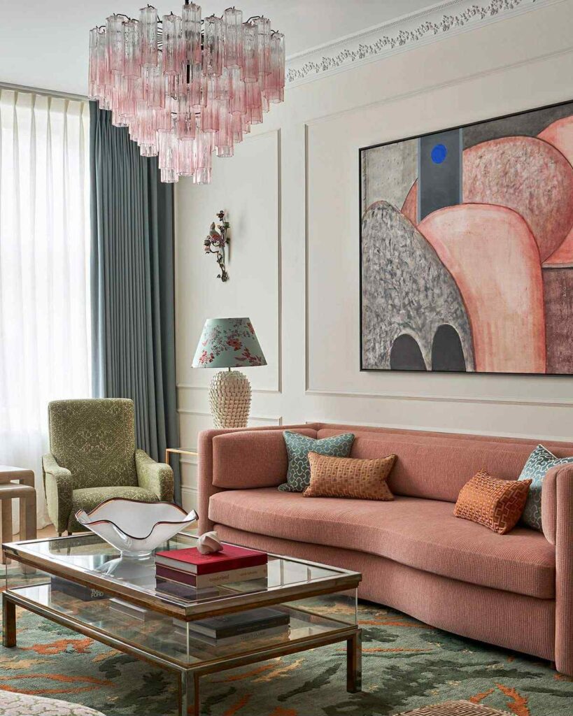 ელეგანტური მისაღები ოთახი ვარდისფერი დივანით და ბროლის ჭაღით.