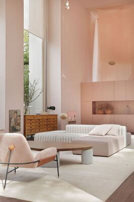 მაღალჭერიანი ნათელი ოთახი ვარდისფერი კედლებით და თანამედროვე ავეჯით