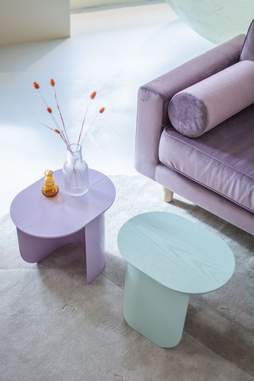 იასამნისფერი ხავერდის დივანი და პასტელური ფერის ჟურნალის მაგიდები