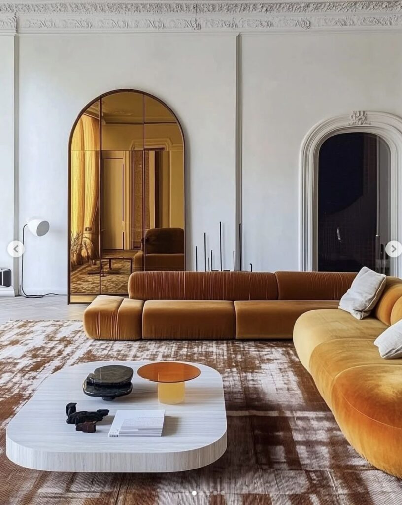 დიდი ყვითელი დივანი და თაღოვანი სარკე ნათელ მისაღებ ოთახში