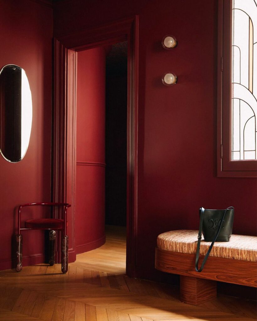 წითელი ფერი ინტერიერის დიზაინში, კადრში ჩანს წითელი კარი და კედლების ხისთან შერწყმაში