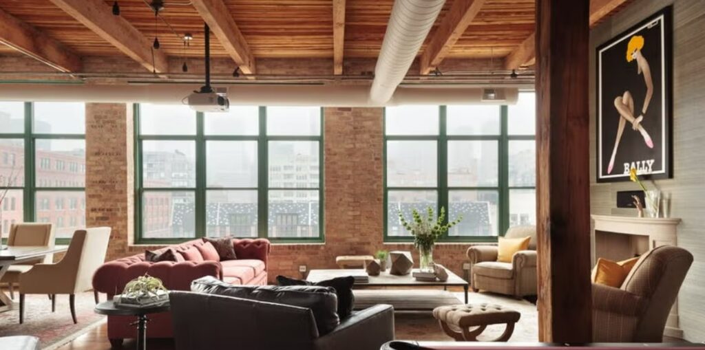 ლოფტის სტილის ინტერიერი: ღია სივრცე, წითელი აგურის კედლები, მაღალი ჭერი და ინდუსტრიული განათება